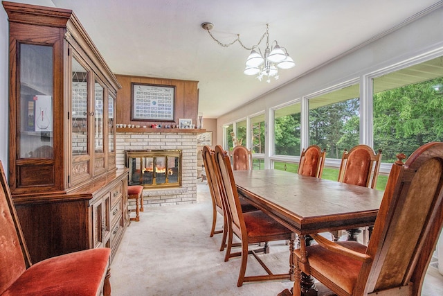 1205 Sassafras Ln, Niles, MI 49120 - dining space with light colored carpet, a brick fireplace, and a chandelier
