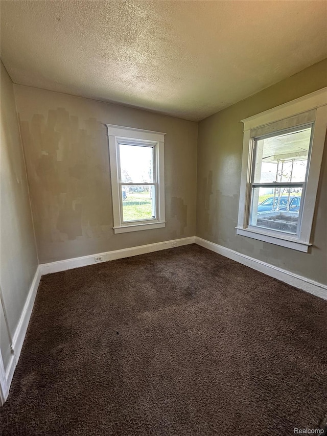 2500 Salt St, Saginaw, MI 48602 - spare room with baseboards, dark carpet, and a textured ceiling