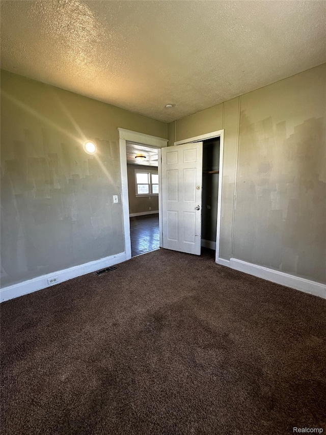 2500 Salt St, Saginaw, MI 48602 - unfurnished bedroom with baseboards, dark carpet, a textured ceiling, and a closet