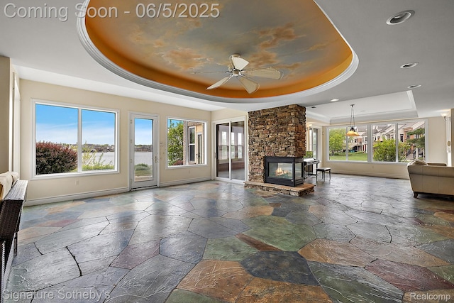10611 Lighthouse Pt, South Lyon, MI 48178 - unfurnished living room with a raised ceiling, stone tile flooring, baseboards, a fireplace, and recessed lighting