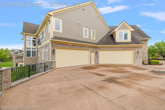 10611 Lighthouse Pt, South Lyon, MI 48178 - view of front of property featuring concrete driveway, an attached garage, roof with shingles, and brick siding