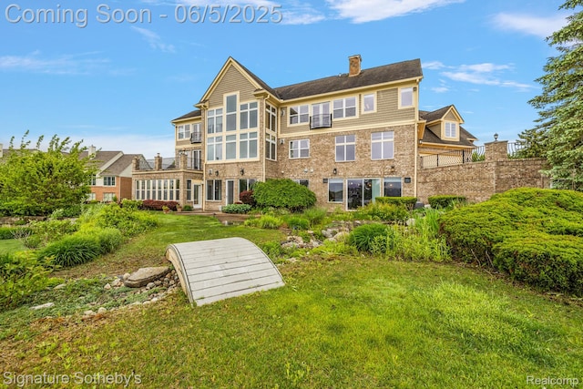 10611 Lighthouse Pt, South Lyon, MI 48178 - rear view of house featuring a chimney and a lawn