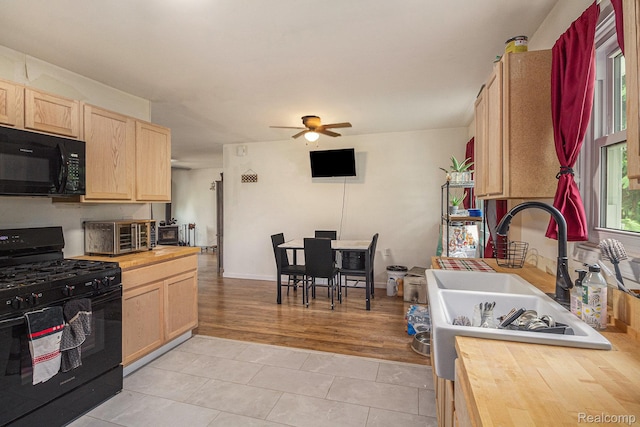 7184 Grand River Rd, Bancroft, MI 48414 - kitchen with black appliances, light brown cabinets, wooden counters, and a sink