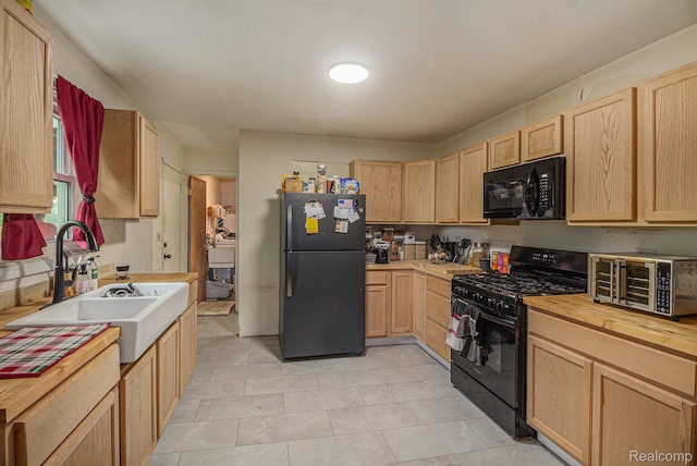 7184 Grand River Rd, Bancroft, MI 48414 - kitchen featuring black appliances, light brown cabinetry, a sink, wood counters, and light tile patterned flooring