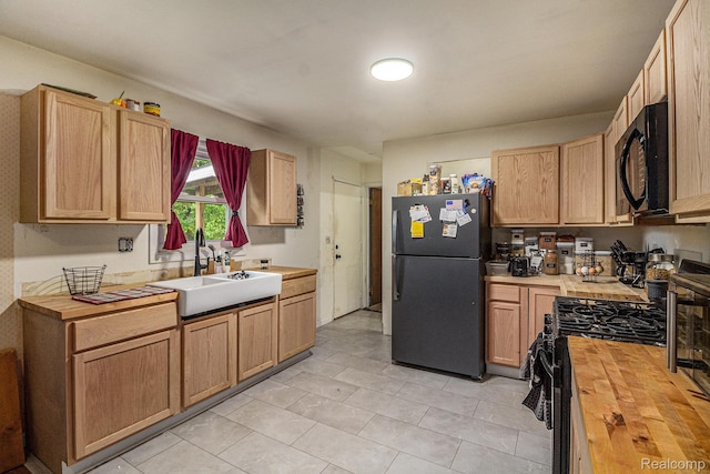 7184 Grand River Rd, Bancroft, MI 48414 - kitchen with freestanding refrigerator, butcher block counters, black microwave, a sink, and gas stove