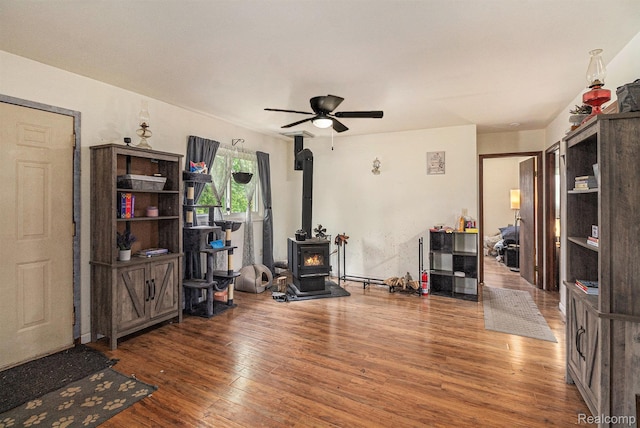 7184 Grand River Rd, Bancroft, MI 48414 - living room with a wood stove, wood finished floors, and a ceiling fan