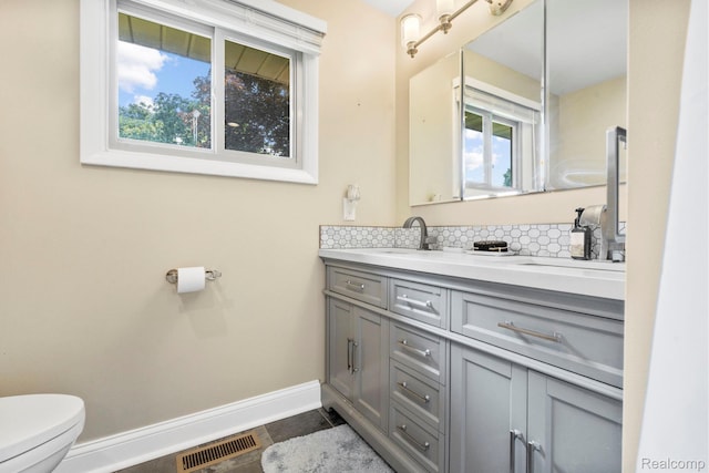 116 Surrey Rd, Saint Louis, MI 48880 - bathroom with toilet, double vanity, baseboards, tasteful backsplash, and tile patterned flooring