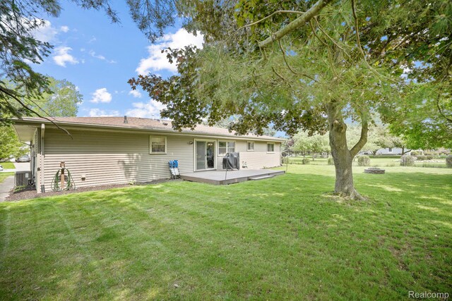 116 Surrey Rd, Saint Louis, MI 48880 - back of property with a yard, a deck, a fire pit, and central air condition unit