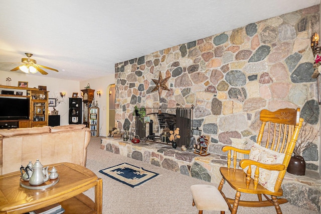 22649 N Dixboro Rd, South Lyon, MI 48178 - living area with arched walkways, a ceiling fan, a textured ceiling, a stone fireplace, and carpet flooring
