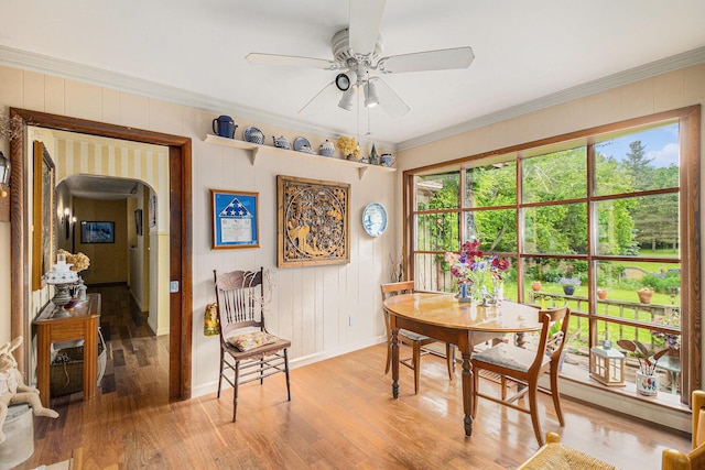 22649 N Dixboro Rd, South Lyon, MI 48178 - dining area featuring light wood finished floors, arched walkways, ceiling fan, baseboards, and crown molding