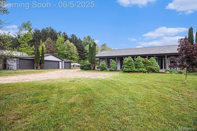 3275 Levalley Rd, Columbiaville, MI 48421 - view of grassy yard featuring a detached garage and an outbuilding