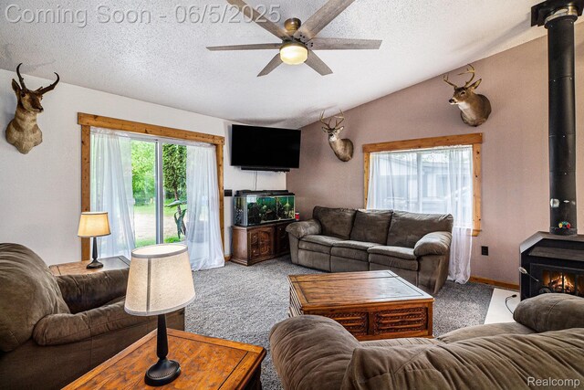 3275 Levalley Rd, Columbiaville, MI 48421 - carpeted living room with a wood stove, a ceiling fan, lofted ceiling, and a textured ceiling