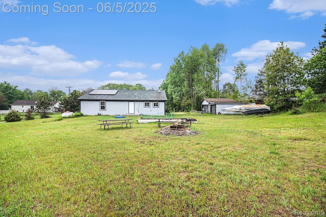 3275 Levalley Rd, Columbiaville, MI 48421 - view of grassy yard featuring an outdoor fire pit