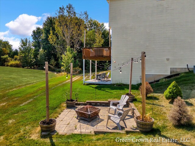 4052 Quest Ct SW, Wyoming, MI 49418 - view of grassy yard with a fire pit, a patio, and a deck