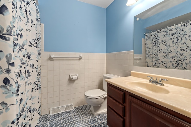 4564 Sparrow Ave, Kalamazoo, MI 49004 - full bathroom with tile walls, toilet, vanity, wainscoting, and a shower with curtain