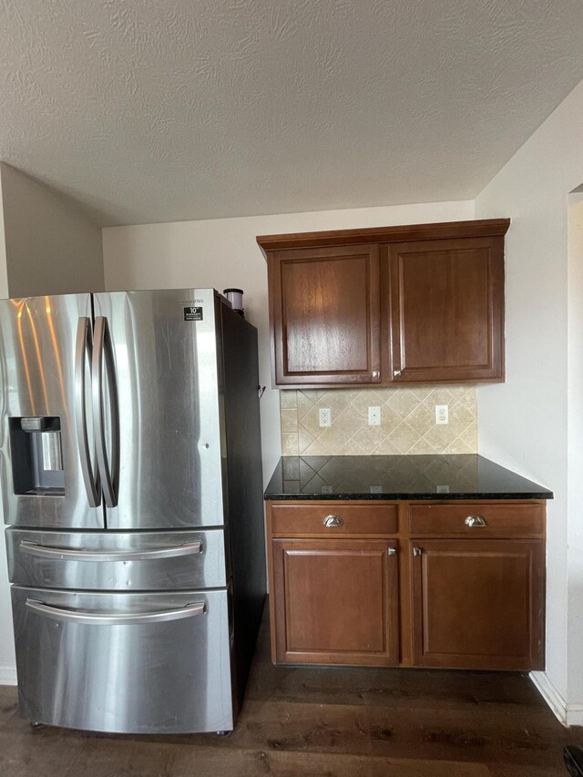 8808 Geiser Grv, Richland, MI 49083 - kitchen featuring stainless steel fridge with ice dispenser, dark wood-type flooring, decorative backsplash, dark stone counters, and a textured ceiling
