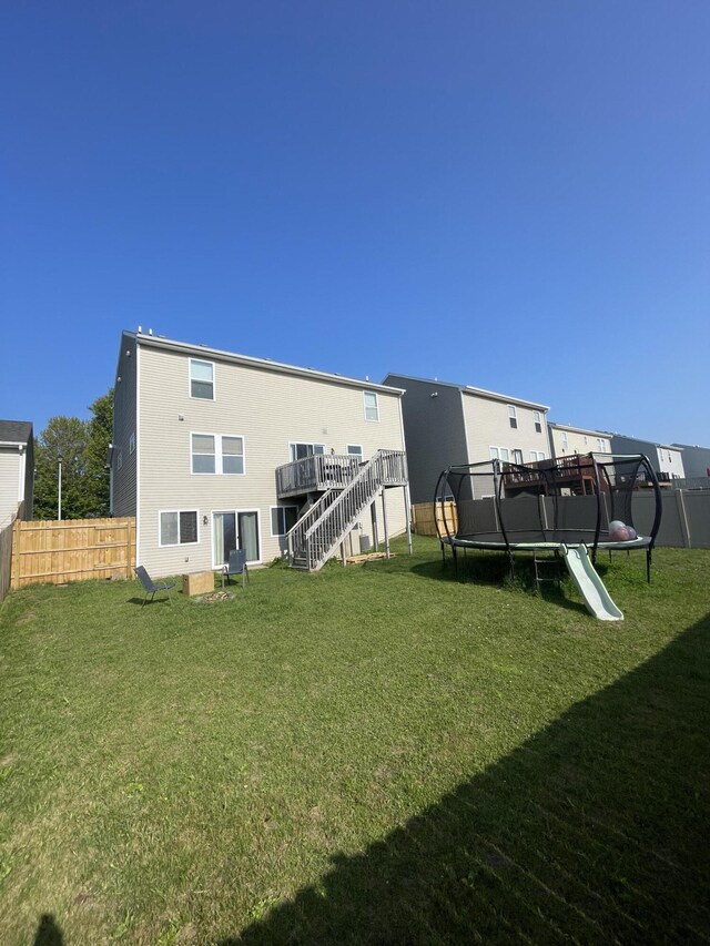 8808 Geiser Grv, Richland, MI 49083 - back of house with a trampoline, stairs, and a wooden deck