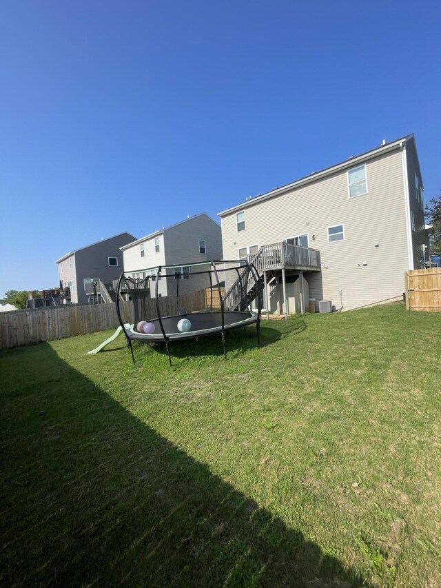8808 Geiser Grv, Richland, MI 49083 - back of property with a trampoline, stairs, a deck, and central AC