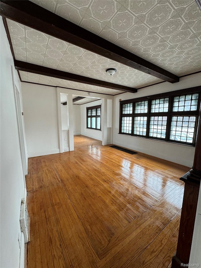 3137 S Washington Ave, Saginaw, MI 48601 - unfurnished living room featuring wood-type flooring, an ornate ceiling, baseboards, and beam ceiling