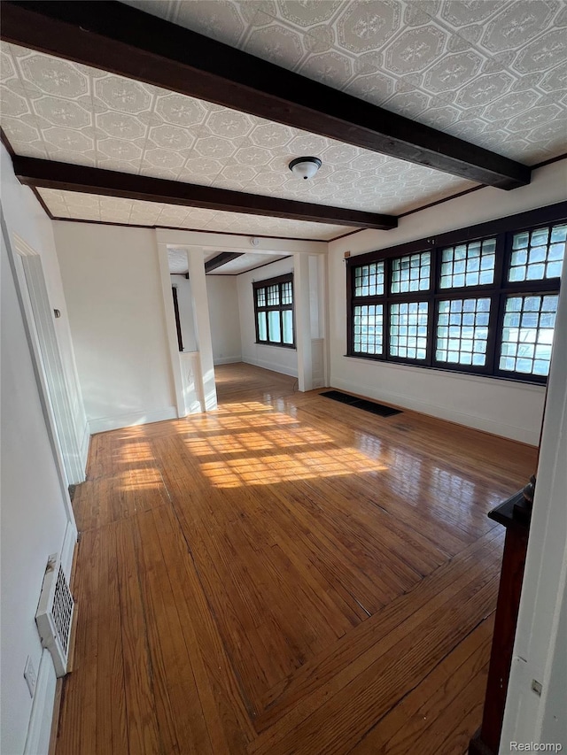 3137 S Washington Ave, Saginaw, MI 48601 - unfurnished living room featuring hardwood / wood-style floors, an ornate ceiling, baseboards, and beam ceiling