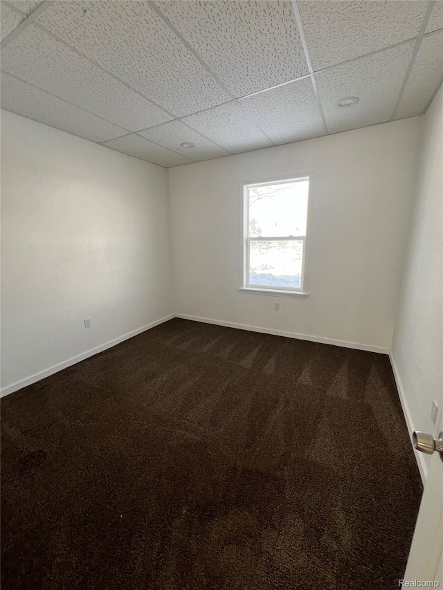 3137 S Washington Ave, Saginaw, MI 48601 - unfurnished room with a drop ceiling, dark colored carpet, and baseboards