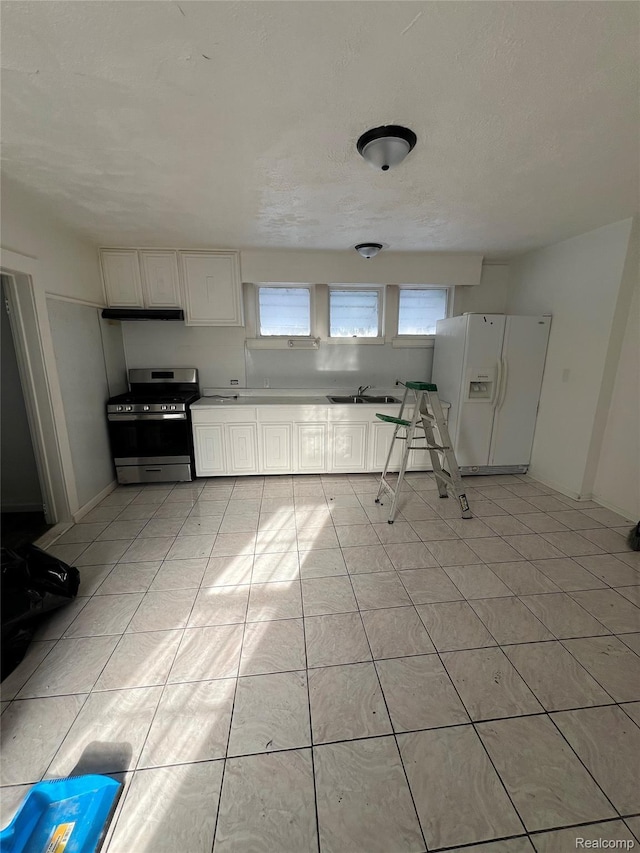 3137 S Washington Ave, Saginaw, MI 48601 - kitchen featuring stainless steel gas range, white refrigerator with ice dispenser, a sink, white cabinetry, and under cabinet range hood