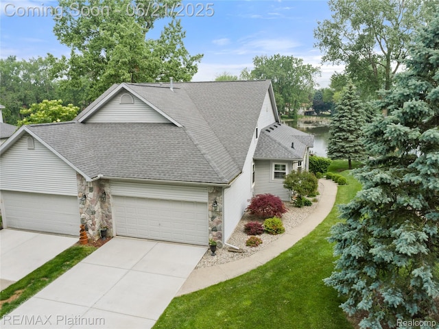 2336 Swans Cv Unit 7, Fenton, MI 48430 - view of front facade featuring a shingled roof, a garage, driveway, stone siding, and a front lawn