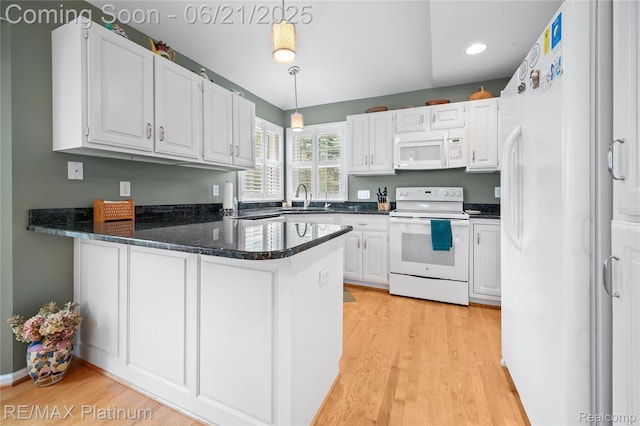 2336 Swans Cv Unit 7, Fenton, MI 48430 - kitchen featuring white appliances, a peninsula, light wood-style flooring, white cabinets, and hanging light fixtures