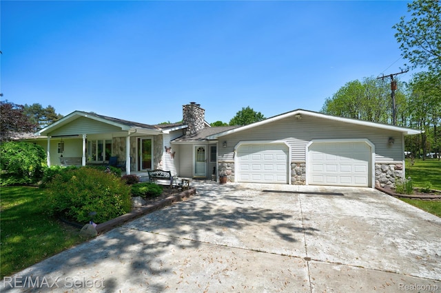 2391 Atwell Rd, Attica, MI 48412 - view of front of home with stone siding, a garage, a chimney, driveway, and covered porch