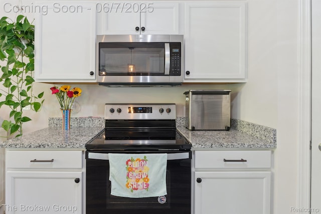 9211 Hawthorn Dr, Davison, MI 48423 - kitchen with appliances with stainless steel finishes, white cabinetry, and light stone countertops