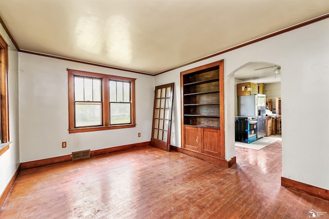 5650 Sylvia St, Dearborn Heights, MI 48125 - unfurnished room with crown molding, arched walkways, hardwood / wood-style floors, and built in shelves