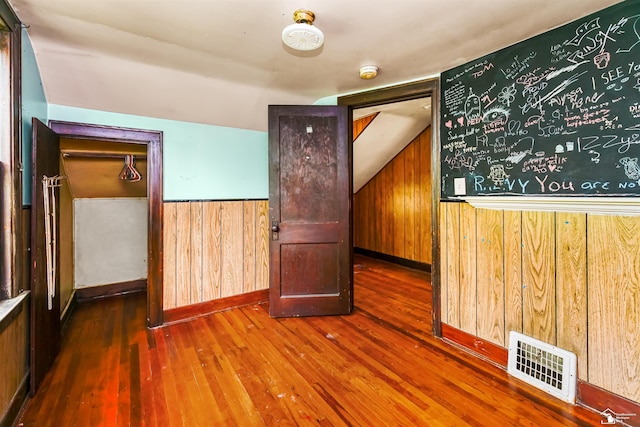 5650 Sylvia St, Dearborn Heights, MI 48125 - spare room with wooden walls, hardwood / wood-style flooring, a smoke detector, and lofted ceiling