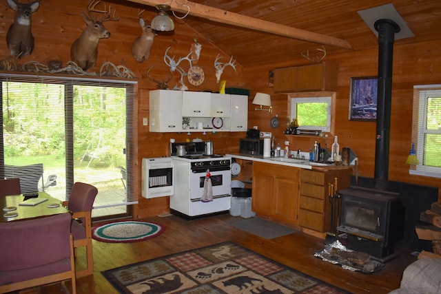 2186 88th St, Bitely, MI 49309 - kitchen featuring gas range gas stove, a wood stove, heating unit, light countertops, and wood finished floors