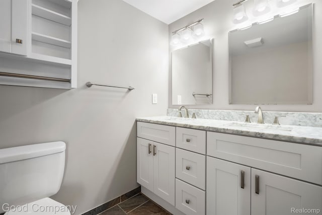 3501 Mann Rd, Clarkston, MI 48346 - bathroom with double vanity, toilet, and baseboards