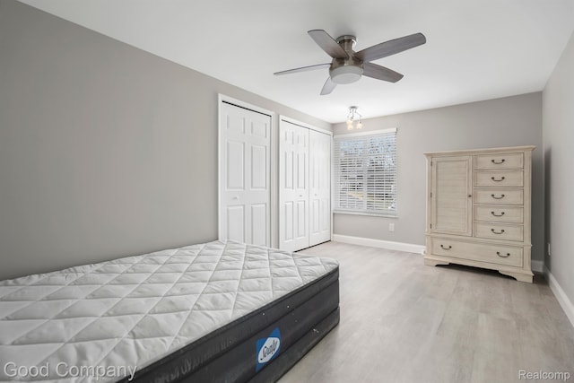 3501 Mann Rd, Clarkston, MI 48346 - bedroom with light wood-style floors, multiple closets, baseboards, and a ceiling fan
