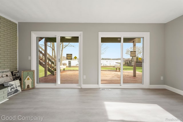 3501 Mann Rd, Clarkston, MI 48346 - doorway to outside with wood finished floors, baseboards, and brick wall