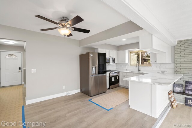 3501 Mann Rd, Clarkston, MI 48346 - kitchen featuring stainless steel appliances, a peninsula, white cabinetry, ceiling fan, and tasteful backsplash