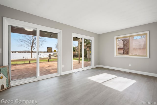3501 Mann Rd, Clarkston, MI 48346 - empty room with a water view, wood finished floors, and baseboards