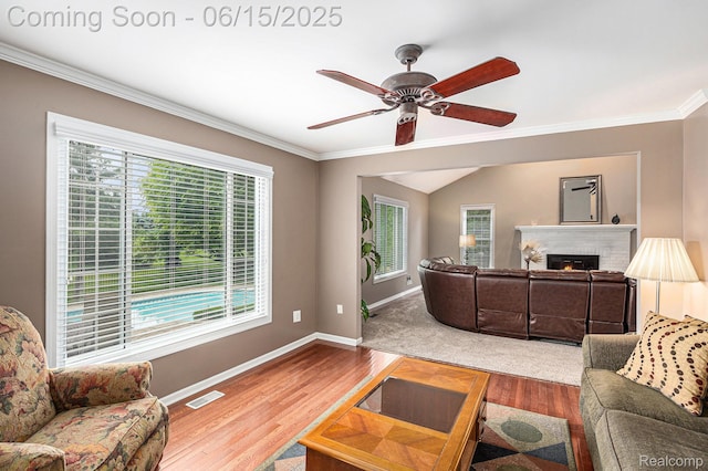 16096 Violet Dr, Macomb, MI 48042 - living area featuring a lit fireplace, wood finished floors, ornamental molding, and a ceiling fan