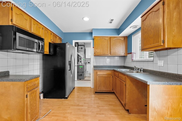 23312 Shoreview St, Saint Clair Shores, MI 48082 - kitchen featuring appliances with stainless steel finishes, decorative backsplash, light wood-type flooring, and dark countertops