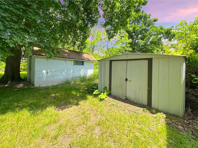 315 E Spruce St, Marshall, MI 49068 - outdoor structure at dusk featuring a storage shed and a lawn