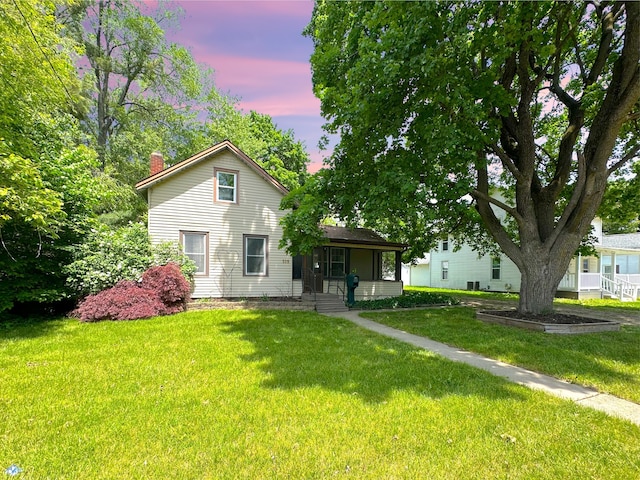 315 E Spruce St, Marshall, MI 49068 - view of front of house featuring a chimney, a front lawn, and covered porch