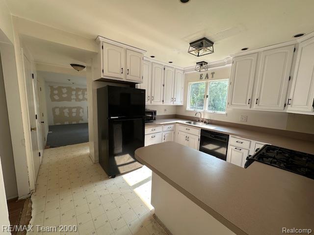 5936 Meadowview St, Ypsilanti, MI 48197 - kitchen with black dishwasher, fridge, stainless steel microwave, white cabinets, and a peninsula
