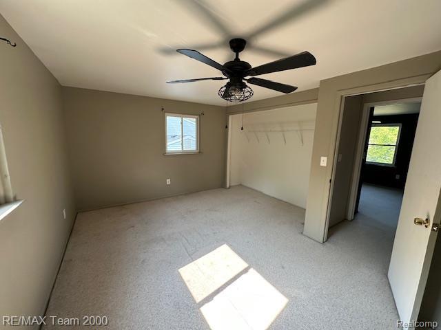 5936 Meadowview St, Ypsilanti, MI 48197 - unfurnished bedroom featuring multiple windows, light colored carpet, a ceiling fan, and a closet