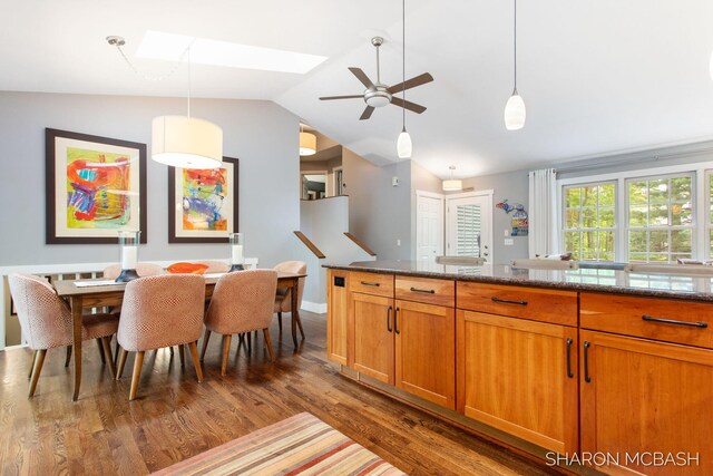 3348 Clearview Ln, Saugatuck, MI 49453 - kitchen with lofted ceiling, dark wood-style flooring, brown cabinets, a skylight, and ceiling fan