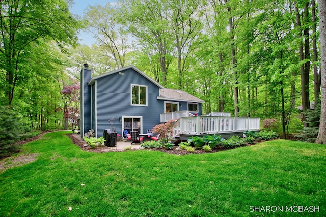 3348 Clearview Ln, Saugatuck, MI 49453 - back of property featuring a chimney, a deck, a yard, and a patio