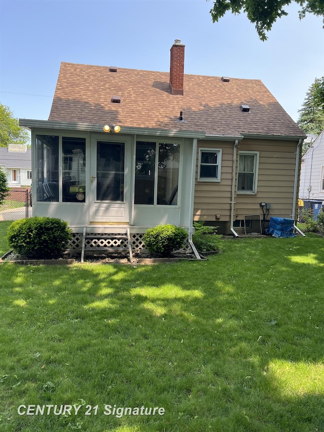 1613 Waldman Ave, Flint, MI 48507 - rear view of house with a chimney, a sunroom, a shingled roof, and a lawn