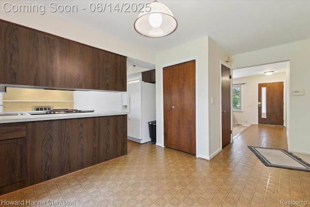 5045 Bronco Dr, Clarkston, MI 48346 - kitchen featuring white refrigerator with ice dispenser, dark brown cabinetry, light countertops, light flooring, and decorative backsplash