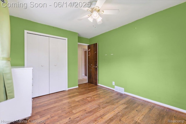 5045 Bronco Dr, Clarkston, MI 48346 - unfurnished bedroom with wood finished floors, a closet, and a ceiling fan