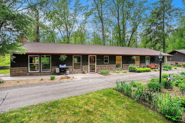 731 13 Mile Rd NW, Sparta, MI 49345 - ranch-style home with stone siding, a chimney, and board and batten siding